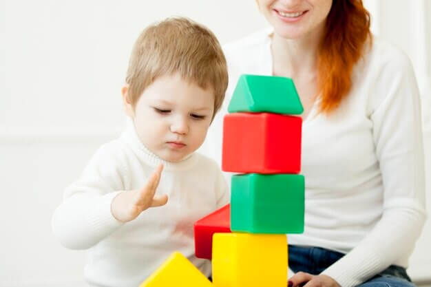 Bébé de 2 ans jouant avec des blocs de jouets colorés