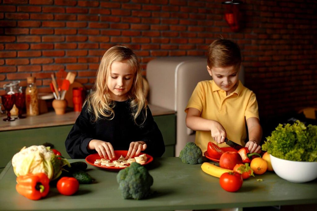Des enfants qui coupent des légumes