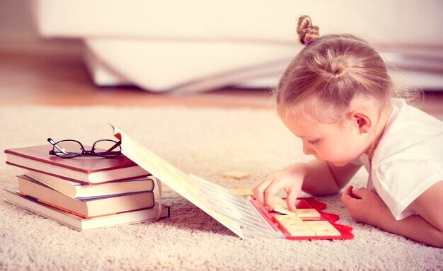 Petite fille apprenant à lire à la maison