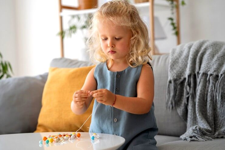 Petite fille confectionne un colier