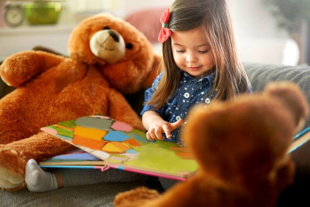 Petite fille lisant un album coloré