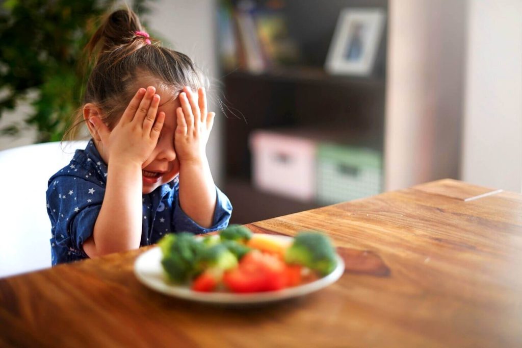 Petite fille qui ne veut pas manger des légumes