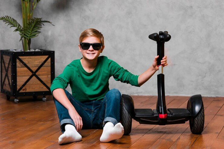 Enfant avec des lunettes fière de son hoverboard