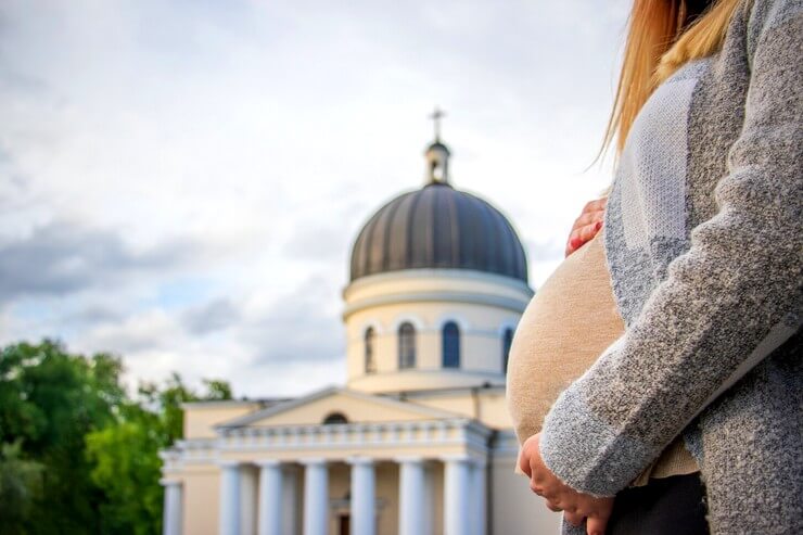 Femme enceinte devant une église