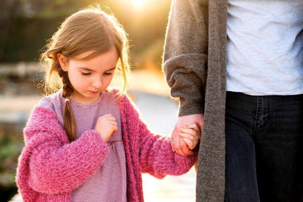 Petite fille triste triste tenant la main de sa mère