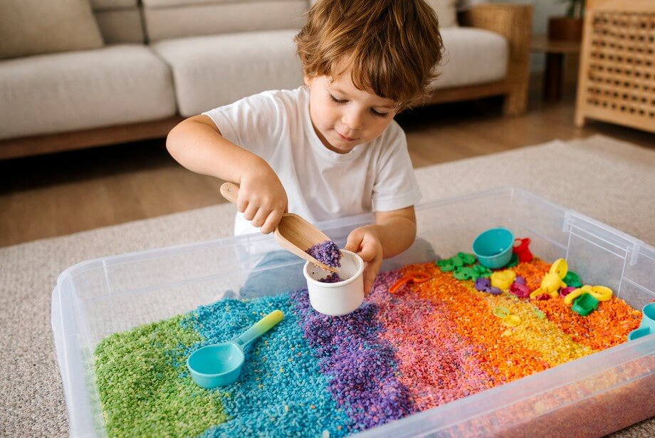 Enfant jouant avec du riz coloré