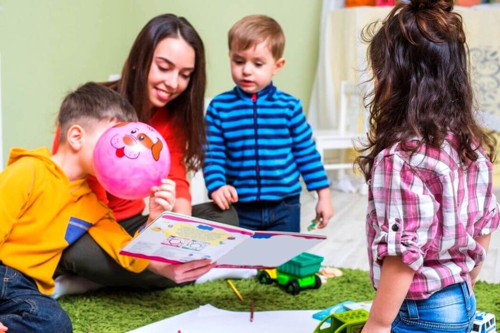 Femme lisant une histoire aux enfants à la crèche