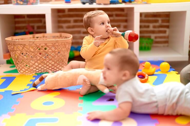 Bambins qui jouent sur un tapis à la crèche