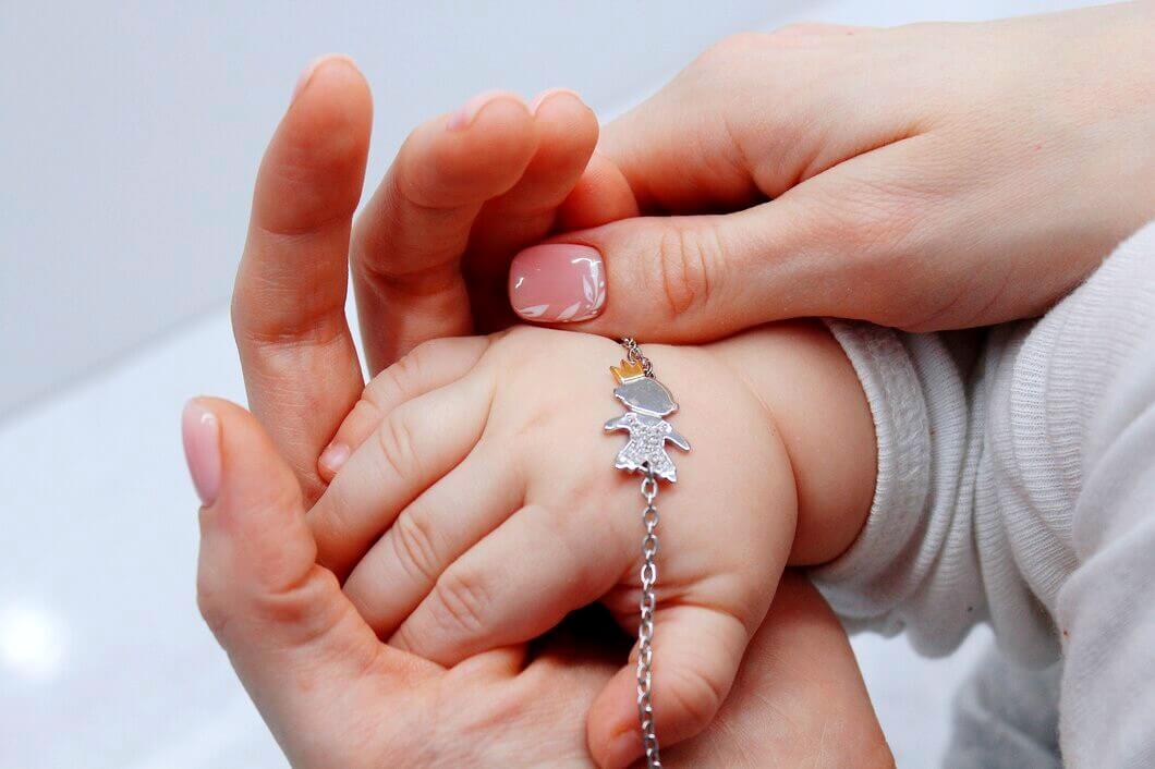 médaille de baptême sur la main d'un bébé