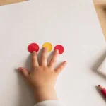 Activité manuelle 2 ans : enfant colle des gommettes